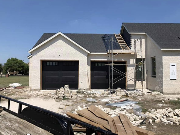 A modern overhead garage door with a sleek design, featuring horizontal panels and a smooth finish, set against a contemporary home exterior.